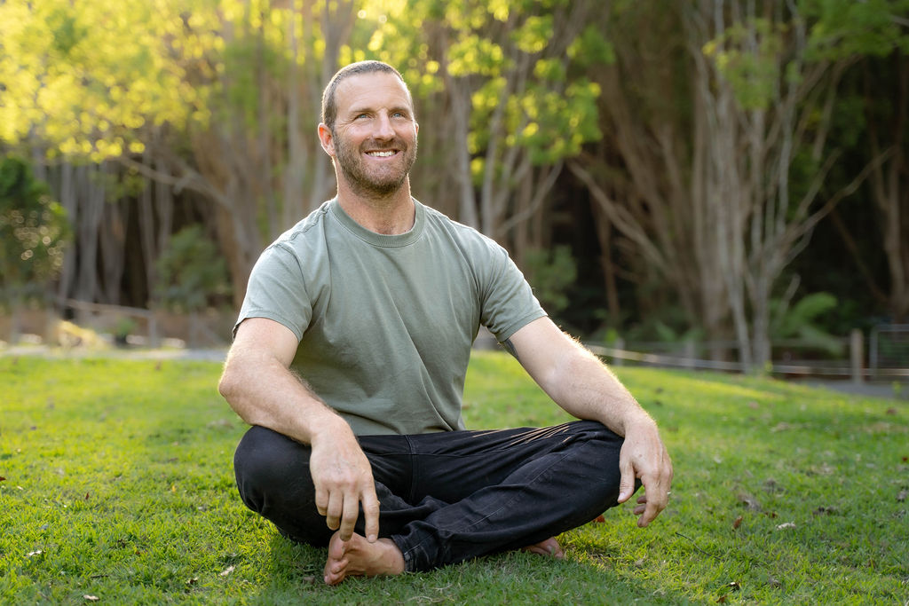 Rich Muir smiling while sitting on the lawn in Currumbin Valley